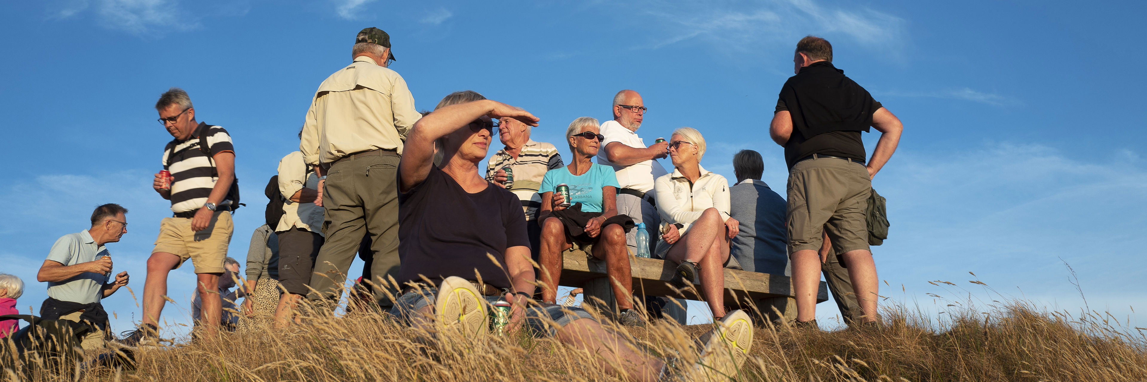 Turister på tur i klitter solnedgang