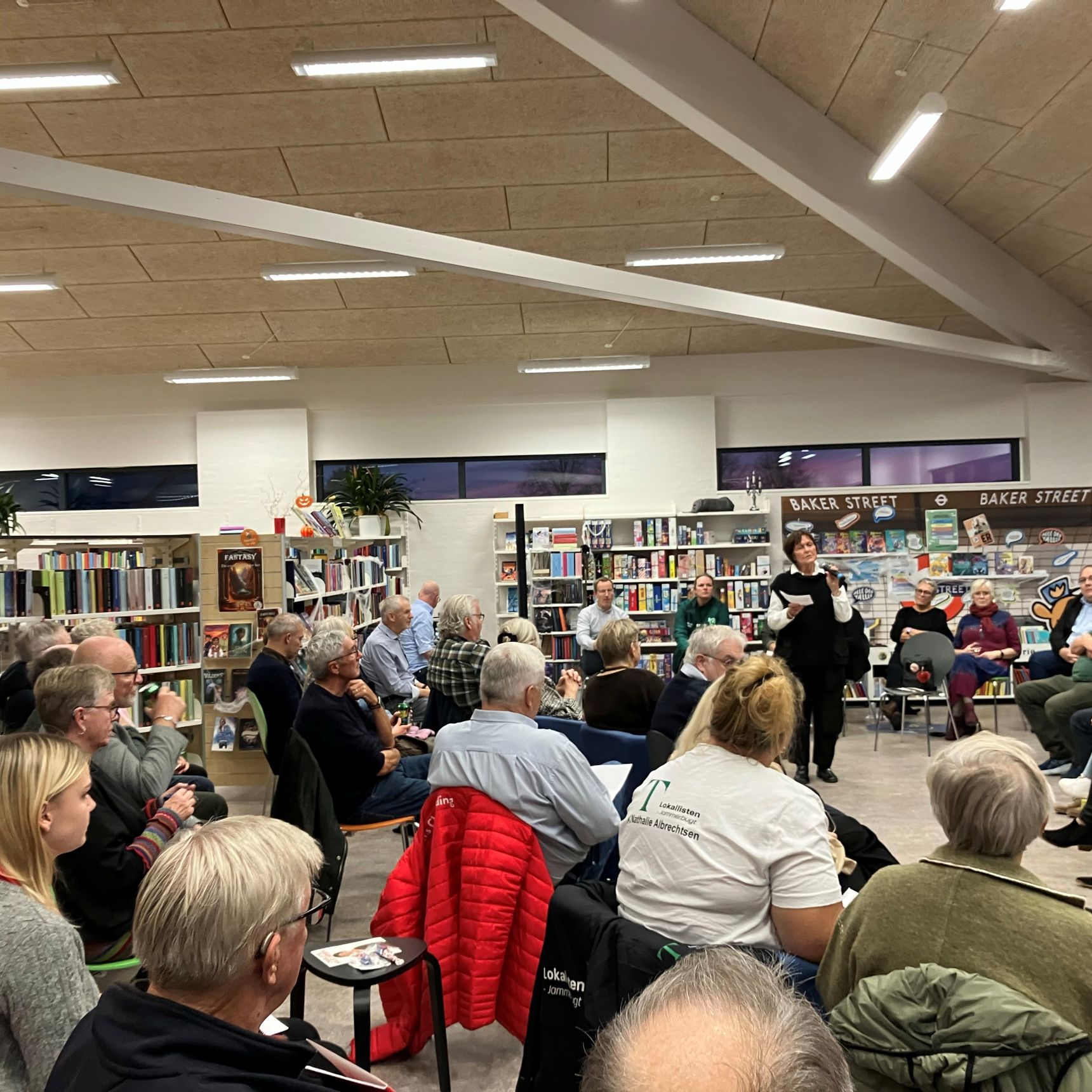 Foredragsholder og publikum på bibliotek
