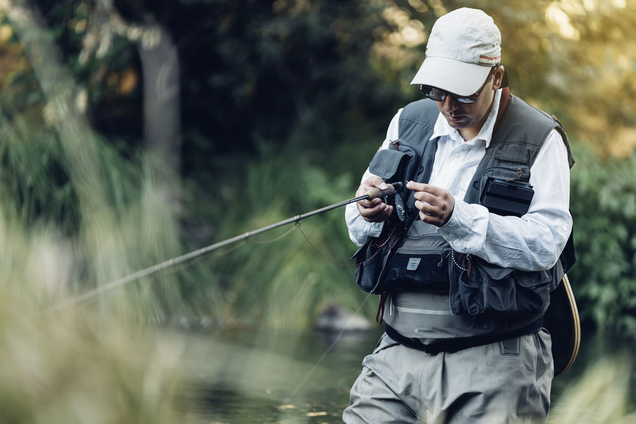 Lystfisker i waders og med fiskestang